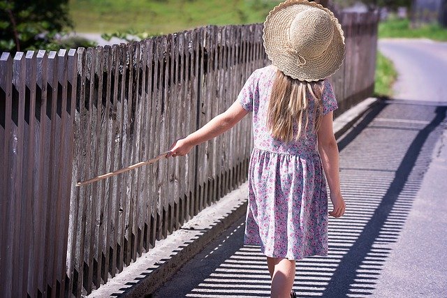 holčička u dřevěného plotu
